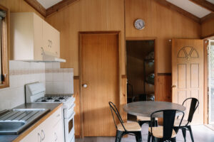 Picture shows a view inside Harrietville Cabins looking at kitchen facilities and dining table